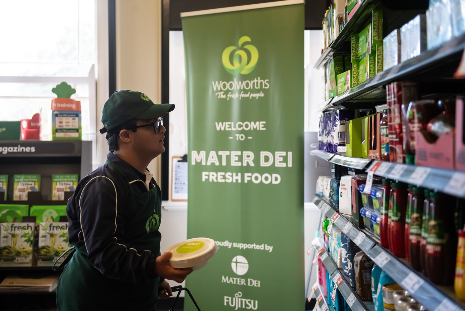 A young man with a learning disability learning how to be an employee for a supermarket chain at school.