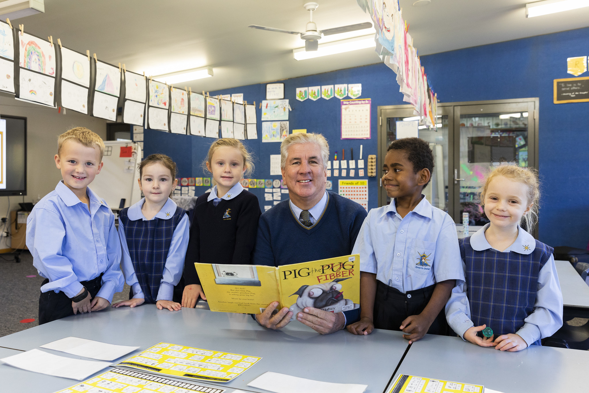 A teacher reading a book to primary school students.