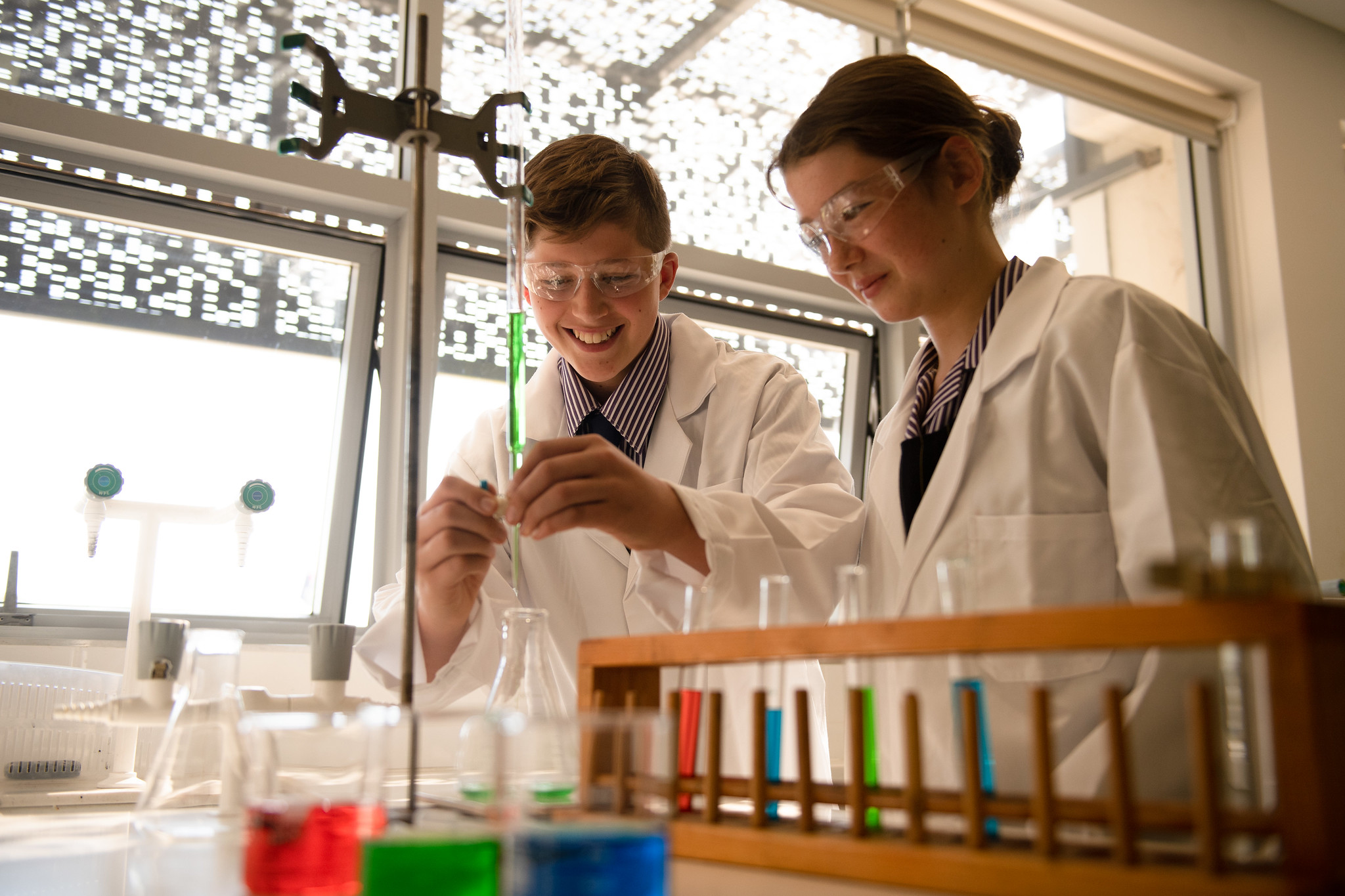 Two kids working with test tubes in science class.