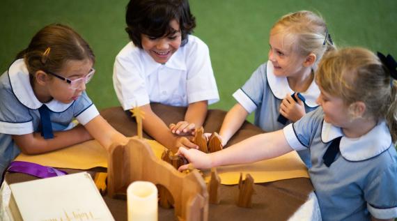 A group of students playing with some wooden blocks.