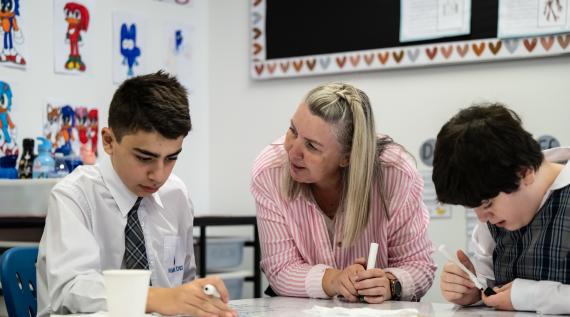 A teacher supporting a child in learning.