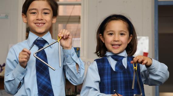 Two kids playing percussion instruments. 