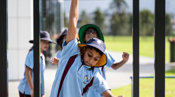 Kids swinging on monkey bars at school.