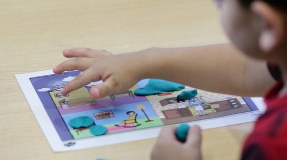 A kid playing with some counting tokens.