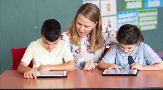 A teacher teaching two young students.