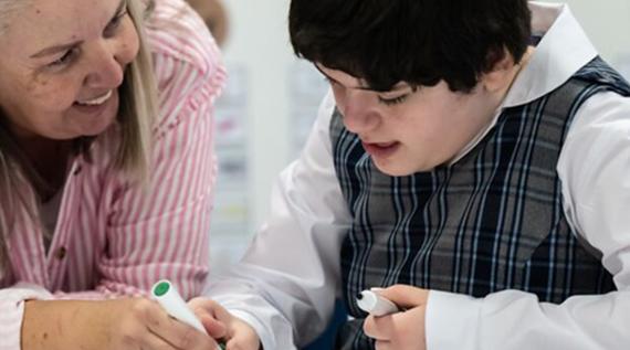 A teacher helping a child with a learning disability.