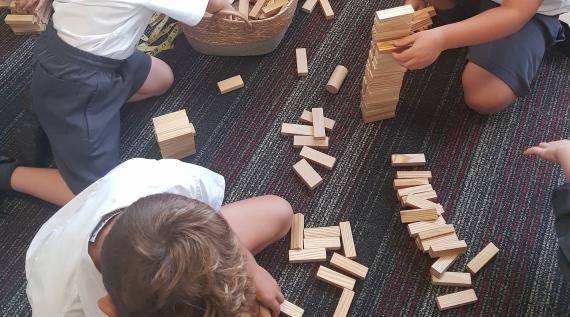 Kids playing with counting blocks on the ground.