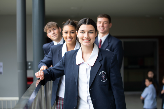 A group of high school students in their Catholic uniforms smiling.