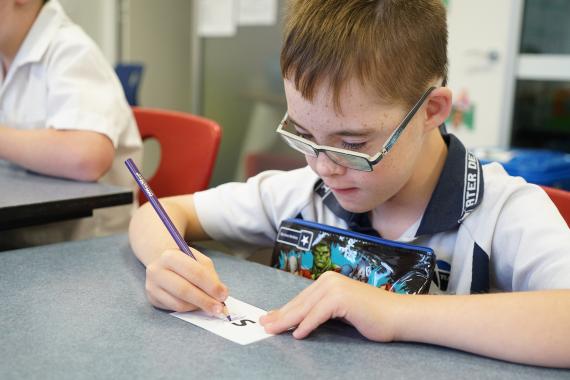 A young boy with an intellectual disability learning to write.