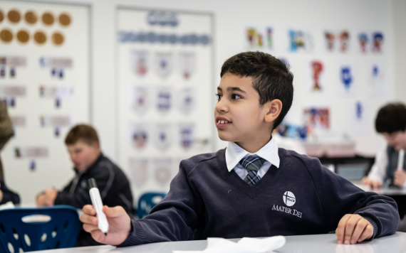 A young boy in class learning.