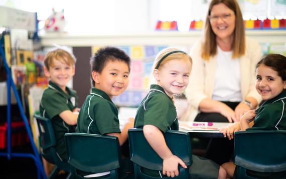 A group of young children being taught by their teacher.