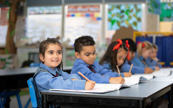 A classroom of kids doing work at their desks.