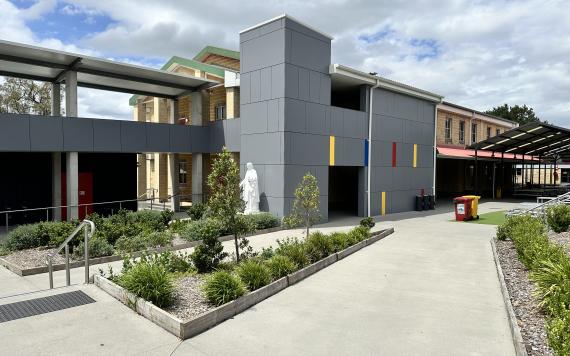 A Catholic school yard and outside of the building. The building is modern and new.