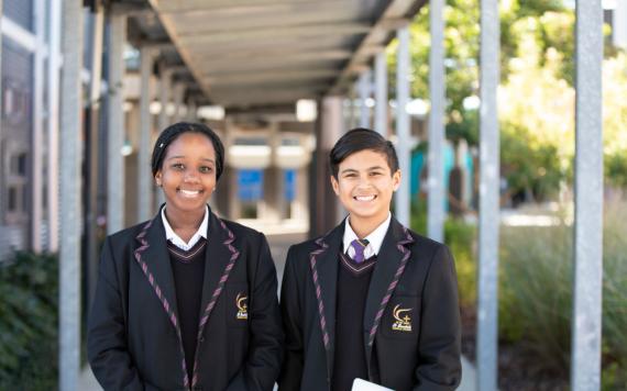 Two high school kids in the school halls walking.