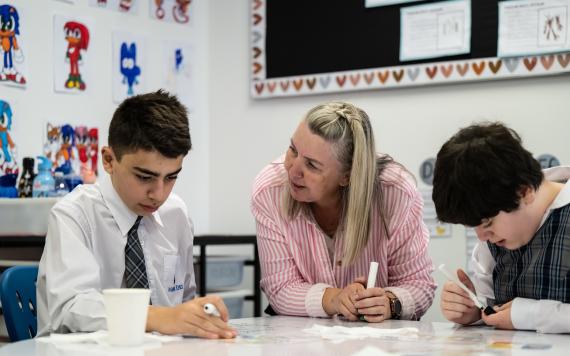 A teacher supporting a child in learning.