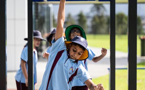 Kids swinging on monkey bars at school.