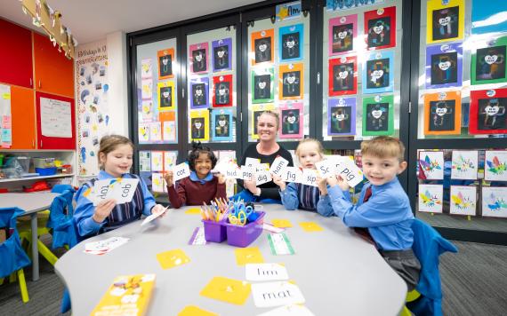 A teacher with young students learning short words like "dig".