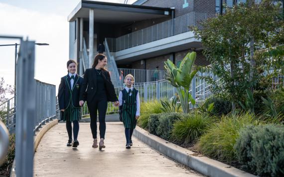 A mother dropping off her two children at a Catholic school.