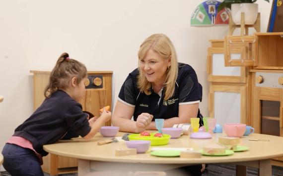 An Early Learning Educator having a tea party with a child.