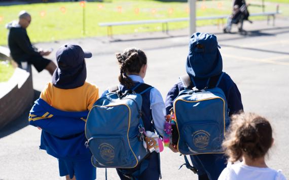 Kids walking into the school grounds.